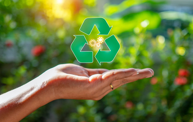 Close up of hand holding green recycle symbol. Recycle concept.